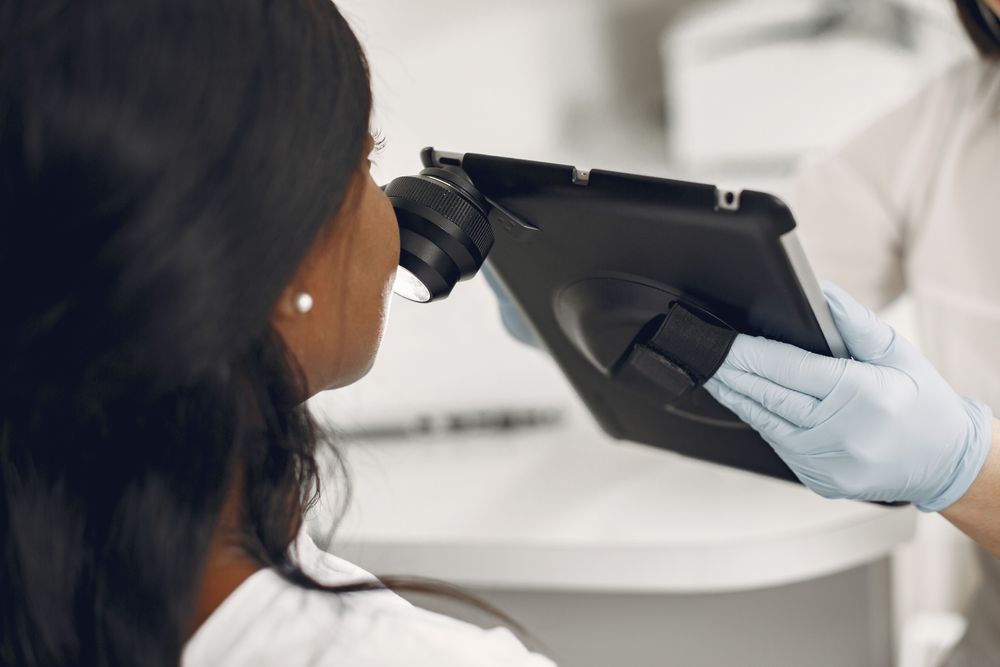 Close-up of a dermatoscope and tablet being used for a detailed skin assessment